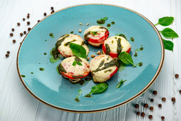 Baked tomatoes with mozzarella cheese and pesto sauce