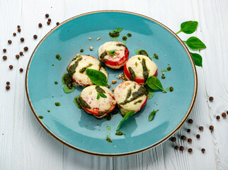 Baked tomatoes with mozzarella cheese and pesto sauce