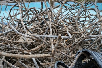 Braun-graue Stahldrahtstapel vor blauem Schwimmbecken im Winter 