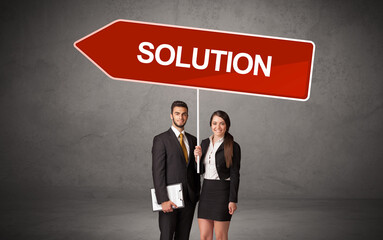 Young business person in casual holding road sign