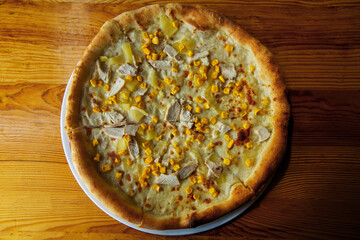 light hawaiian pizza with chicken corn and pineapple summer background