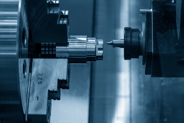 The  CNC turn-mill machine chamfer cutting the metal shape parts.