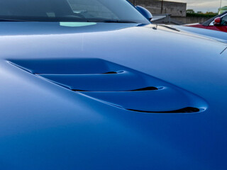 Air intakes on the hood on blue sports cars