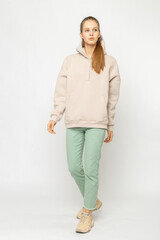 Fototapeta na wymiar Girl in green cargo pants and beige hoodie isolated on white