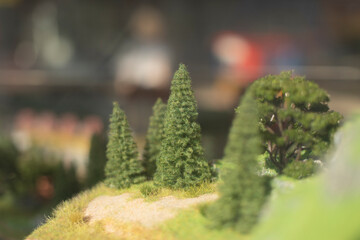 Small trees. Model of mountainous terrain and forests. Toy world.