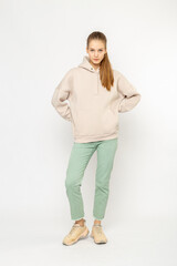 Girl in green cargo pants and beige hoodie isolated on white