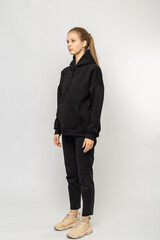 Girl in black cargo pants and black hoodie isolated on white