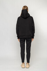 Fototapeta na wymiar Girl in black cargo pants and black hoodie isolated on white