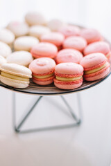 stylish children's candybar with a cake and macarons for a one year party in gentle tones of white and pink colors