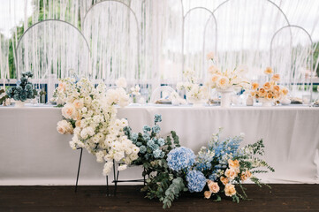 Outdoor banquet and modern design for wedding ceremony in summer. Linen tablecloth, candles, flowers and accessories, glasses and plates on table for guests with chairs, flat lay, nobody