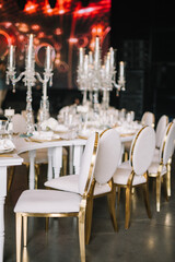 Dinner table decorated by candles and flowers. Wedding. Decor