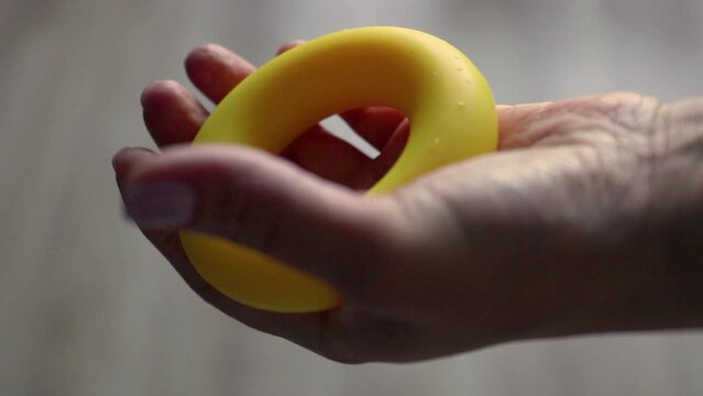 female hand compresses and unclenches the expander, rehabilitation after injury