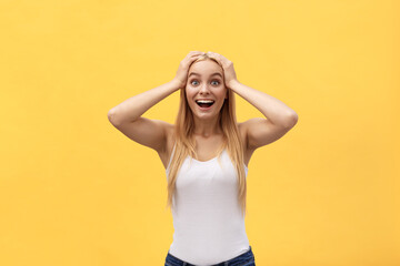 Fototapeta Surprised happy beautiful woman looking at camera in excitement. Isolated on yellow background obraz