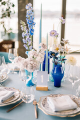 Festive wedding table. Stylish wedding table decoration and table setting in rustic style. Blue tablecloth. Vintage vase
