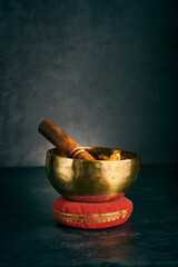 tibetan bowl on a red cushion in a dark background