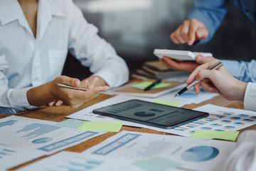 Business team working together planning investment at meeting. Close up view of business people advisors pointing at graph and analyzing financial report.