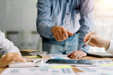 Business team working together planning investment at meeting. Close up view of business people advisors pointing at graph and analyzing financial report.