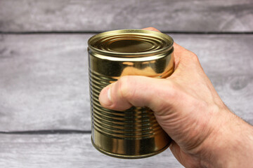 Canned food on hand. A man holds a jar of canned food in his hand.Natural preserves.