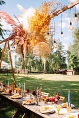 Boho wedding table set. vintage dining table with decorations, flowers and pampas grass  Boho style. Table set for an event, party, date or wedding.