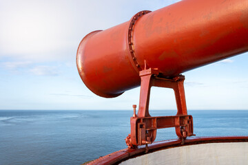 A rather large, now decommissioned red fog horn. - obrazy, fototapety, plakaty