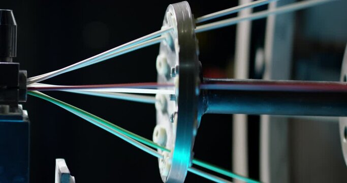 The assembly of a color cable in close-up in the workshop of the production of electric cable for defense enterprises. Shooting at close range.