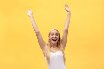 Naklejka na ściany i meble Young beautiful happy girl with hand in the air portrait isolated on yellow background.
