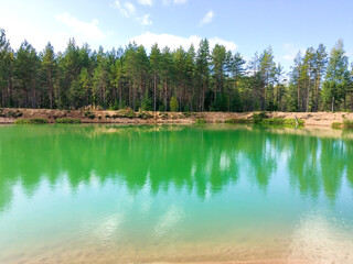 Forest quarry with green water