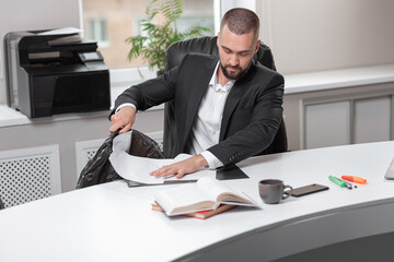 handsome, bearded man in office business suit throws out garbage