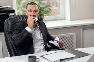 Businessman furiously tearing paper with his teeth and hands