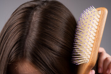 Closeup hair loss, hair fall in hairbrush, stress problem of woman with a comb.