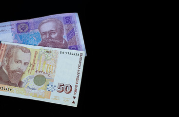 Ukrainian hryvnia and Bulgarian lev on a black background