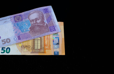 Ukrainian hryvnia and euro on a black background
