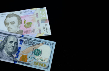 Ukrainian hryvnia and dollars on a black background
