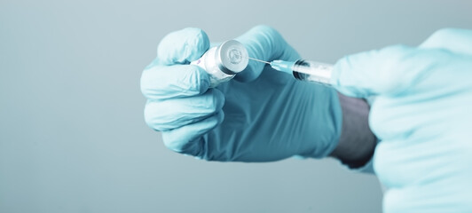 a doctor holding a syringe ready to give a vaccine injection - obrazy, fototapety, plakaty