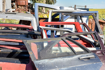 Old damaged cars in the junkyard. Car graveyard. Car doors.