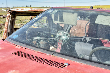 Broken windshield. Old damaged cars in the junkyard. Car graveyard.