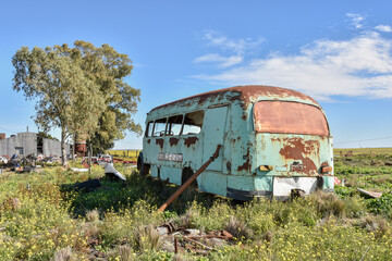 Dismantled and abandoned bus. Old damaged cars in the junkyard. Car graveyard.