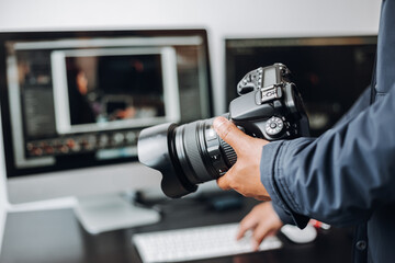 photographer hand camera and computer on desk