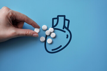 A lot of pills on the silhouette of the heart. A symbol of the treatment of heart diseases