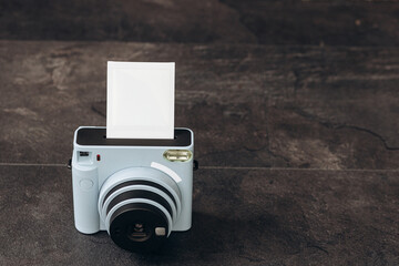 Vintage photo camera on dark background with photo cards. Polaroid camera