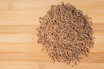 Top view hill of wheat grains on wooden background, space for text