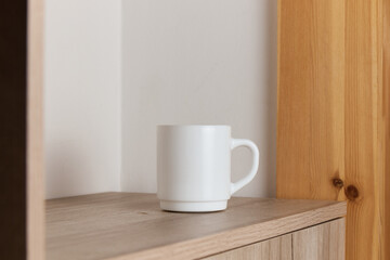 White mug for tea and coffee in on a wooden table, close-up