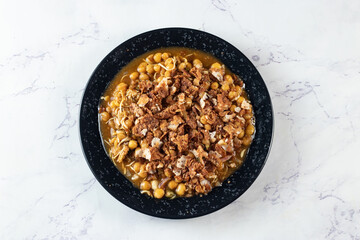 Spicy Chana chat masala chotpoti in a black dish isolated on background top view of indian, bangali and pakistani food chat pata food