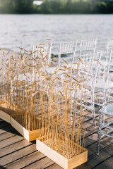 Spikelets of wheat. Wedding by the river. Beach wedding venue. Wooden stage