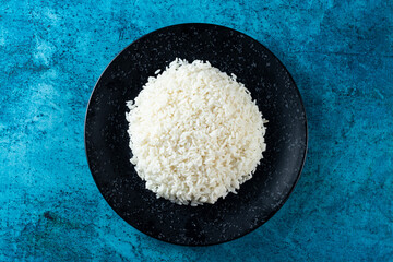 Plain boiled rice in a plate top view on marble background