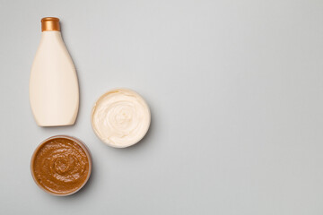 Natural scrub, body cream, shower gel on color background, top view