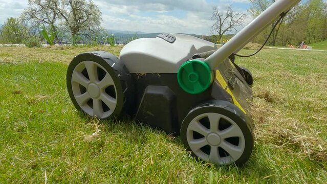 CLOSE UP: Lawn aeration for soil compaction relief and grass growth enhancement. Spring backyard garden work for healthy and thick lawn. Useful gardening machinery for better efficiency at landscaping