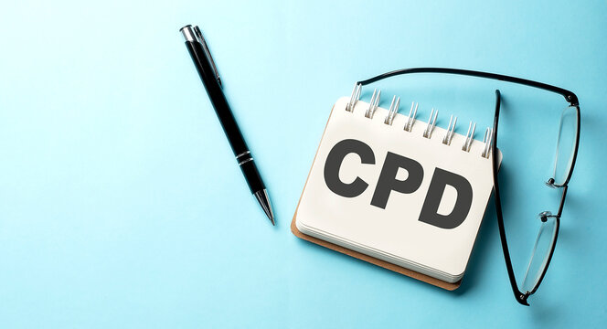 CPD text written on a notepad on the blue background