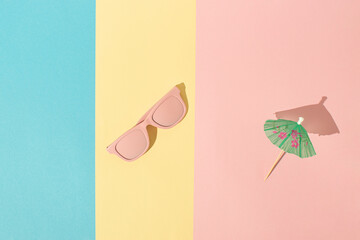 Colorful composition with pink sunglasses and umbrella. Minimal beach background concept. Summer relaxation idea.