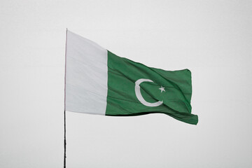 Islamic Republic of Pakistan flag blowing in the wind. Huge Pakistani flag on a pole.